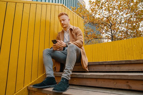 Man sitting on staircase while texting on the phone (Horizontal)kopie.jpg
