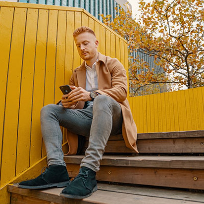 Man sitting on staircase while texting on the phone (Horizontal)kopie.jpg