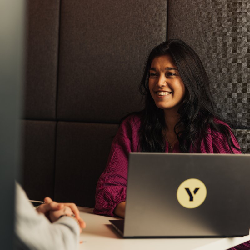 Girl with laptop smiling at colleagu