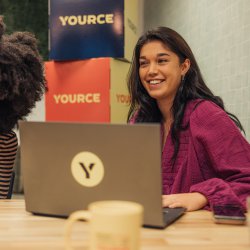 Two girls with laptop smiling during meeting